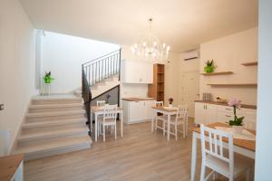 a kitchen and living room with a staircase and a table and chairs at ESSENZA in Massafra