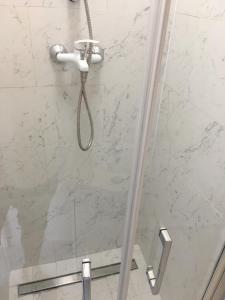 a shower with a glass door with a shower head at Familly Apartament 4 in Międzyzdroje