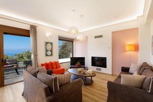 ein Wohnzimmer mit 2 Sofas und einem TV in der Unterkunft Margo villa in Gállos