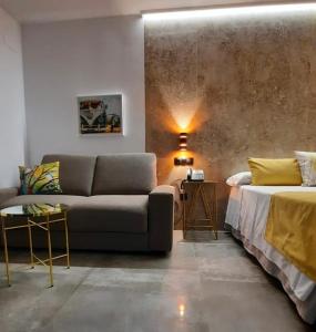 ein Wohnzimmer mit einer Couch und einem Bett in der Unterkunft HOTEL Boutique ÁNGEL in Santa Cruz de Mudela
