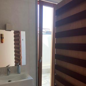 a bathroom with a sink and a mirror at Sossego Salgado in Tavira +4 photos