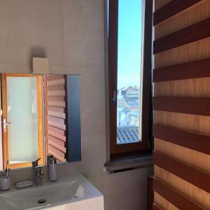 a bathroom with a sink and a window at Sossego Salgado in Tavira