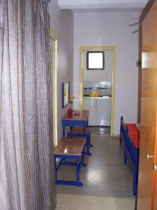 een kamer met een tafel, banken en een raam bij Rose Garden Rooms in Moraitika