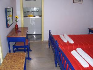 een kamer met 2 bedden, een tafel en een keuken bij Rose Garden Rooms in Moraitika +10 foto's