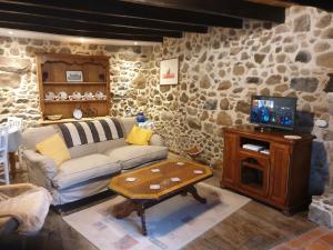 a living room with a couch and a table at Bay Cottage Gite, Busserolles. in Busserolles