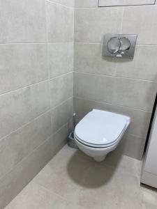 a bathroom with a toilet in a tiled wall at Уютная квартира, в центре города in Tiraspol