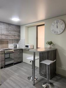 a kitchen with a table and a clock on the wall at Уютная квартира, в центре города in Tiraspol