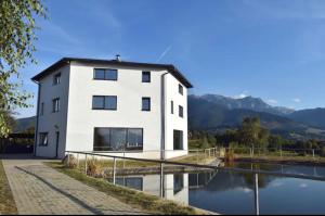 a white building next to a body of water at Vila Panorama in Sohodol
