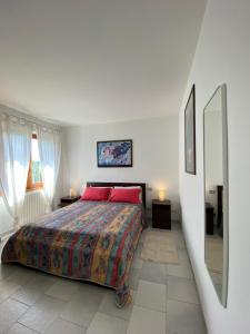 a bedroom with a bed with red pillows and a mirror at Landscapesilvia Acqua in Menaggio