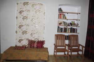 a living room with two chairs and a table and a book shelf at Kera in Tsinandali