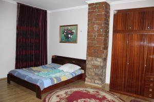 a bedroom with a bed and a brick pillar at Kera in Tsinandali