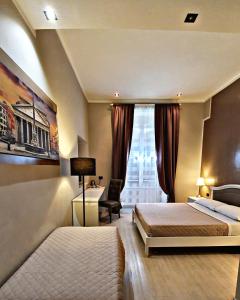 a bedroom with two beds and a desk and a window at Fabio Massimo Guest House in Rome