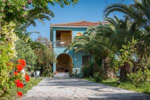 a house with palm trees and a driveway at Dionysia's Apartments in Tsilivi