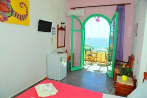 a room with a refrigerator and a door to a balcony at Erofili Rooms in Agia Galini