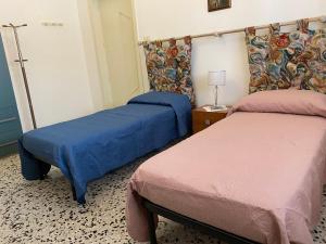 ナルドにあるCasa vacanzeの青とピンクのシーツが備わるベッド2台が備わる客室です。