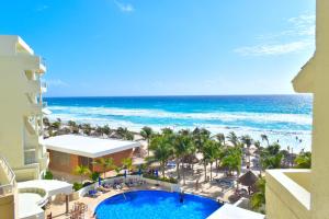 a beach filled with lots of blue and white umbrellas at Hotel NYX Cancun in Cancún