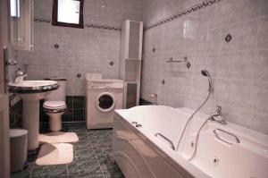 a bathroom with a tub and a toilet and a sink at Apartment Đakovo in Ðakovo