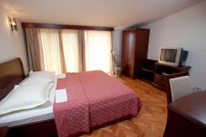 a hotel room with a bed and a television at Agava Apartments Begic in Makarska