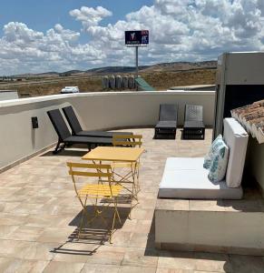 a patio with a table and chairs on a roof at HOTEL Boutique ÁNGEL in Santa Cruz de Mudela