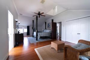 sala de estar con ventilador de techo y sofá en Aria & Mare Hamptons, en Hampton Bays