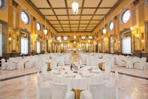 un gran salón de banquetes con mesas blancas y sillas blancas en Balneario de Cestona, en Zestoa