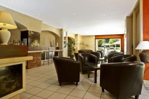 a waiting room with leather chairs and a bar at Hôtel des Roches - Climatisation in Les Eyzies-de-Tayac