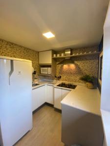 a kitchen with white cabinets and a white refrigerator at SUÍTE DO ENCANTO - Centro Petrópolis in Petrópolis +5 photos