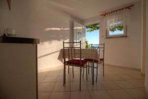 a dining room with a table and chairs and a window at Kaka in Sveti Juraj