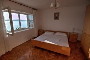 a bedroom with a large bed and a large window at Kaka in Sveti Juraj