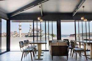 a restaurant with tables and chairs and a view of the city at Mest Hotel Istanbul Sirkeci in Istanbul