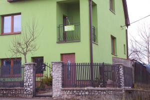 a green house with a gate and a fence at Privat Bajka 2 in Spišské Bystré +4 photos