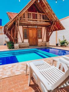 a villa with a swimming pool and a house at Hostal Victoria Club A&C in Arboletes