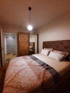 a bedroom with a large bed and a light fixture at Apartment Alex in Bar