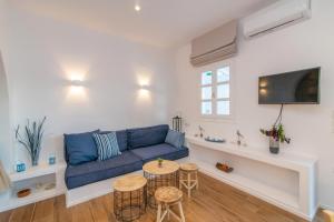 a living room with a blue couch and a table at FOULI'S HOUSE II in Agios Ioannis