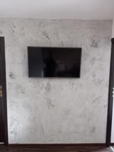 a flat screen tv on a white marble wall at Laura's Apartments in Zakopane