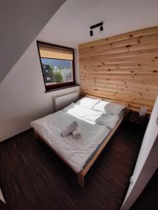 a bedroom with a large bed with a wooden wall at Laura's Apartments in Zakopane
