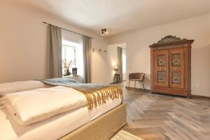 a bedroom with a large bed and a wooden cabinet at Townhouse by Frauenzimmer in Abtenau