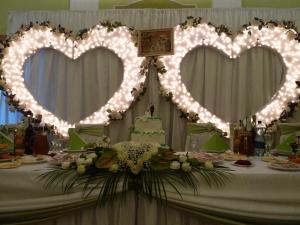 una mesa con dos luces en forma de corazón y un pastel en Hotel Zelenyi Klyn, en Ivano-Frankivsk