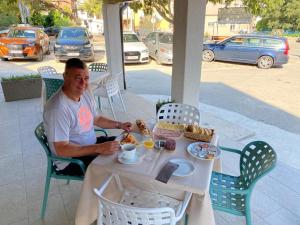 a man sitting at a table with a plate of food at Elizabeta Deluxe Rooms in Biograd na Moru