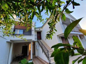 a white house with stairs and a balcony at Apartments Aneta in Ulcinj