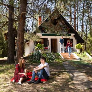 een groep mensen die voor een huis zitten bij Ladybird Lodge in Bela Crkva