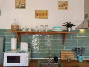 a kitchen with a sink and a microwave at Agua Amarga Design in Agua Amarga
