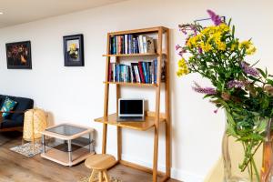 a room with a book shelf and a vase of flowers at Finest Retreats - Number Seven in Skipton