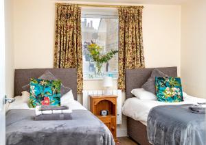 a bedroom with two beds and a window at Finest Retreats - Number Seven in Skipton