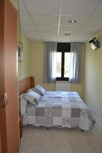 1 dormitorio con 2 camas y ventana en Hostal Bartis en Figueras