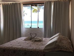 a bedroom with a bed with a view of the ocean at Pousada Verdes Mares in Praia do Frances