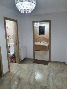 Zimmer mit einem Schlafzimmer mit einem Bett und zwei Spiegeln in der Unterkunft Kriss Apartment Luxury in Târgu Jiu