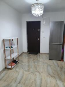 Zimmer mit einer schwarzen Tür und einem Kühlschrank in der Unterkunft Kriss Apartment Luxury in Târgu Jiu