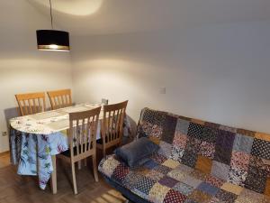a dining room with a table and a quilt on a couch at ATMOSPHERE Apartments in Bled