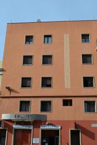 un bâtiment brun avec une horloge sur son côté dans l'établissement Hostal Bartis, à Figueres